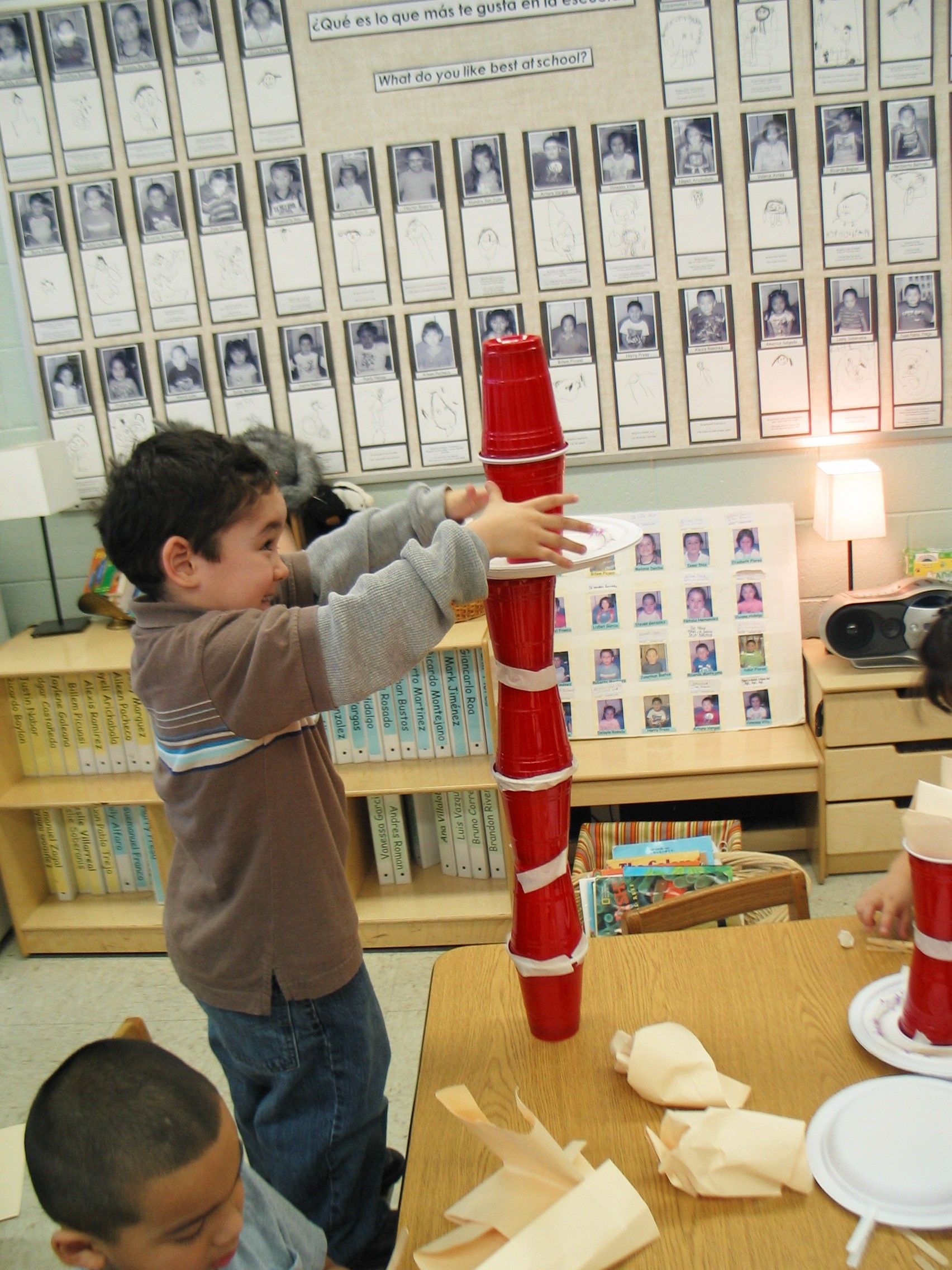 A boy is stacking cups on top of each other.