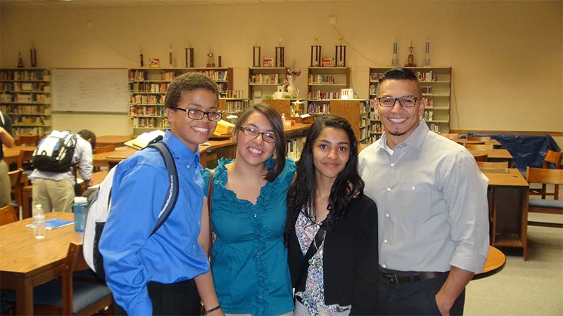 A group of people standing in front of some books.